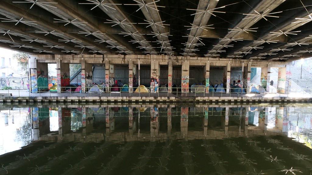 Campement de SDF le long du canal de l'Ourcq. Au dessus, le périphérique Parisien